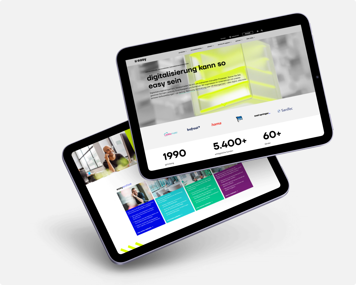 Easy Software Tablets Zwei Tablets schweben vor grauem Hintergrund. Auf den Tablets ist die easy-Website abgebildet.